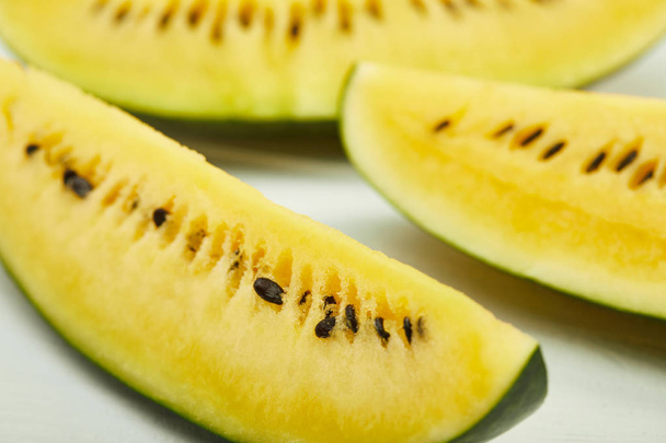 yellow tasty watermelon with seeds on white wooden table - Фото, изображение