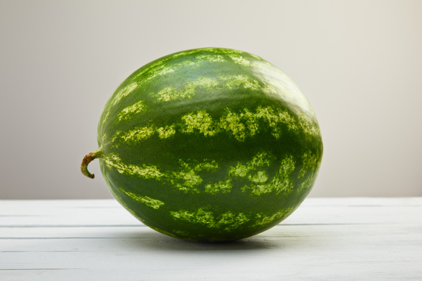 ripe whole tasty watermelon on white wooden table isolated on grey - Fotoğraf, Görsel