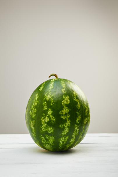 reife ganze Wassermelone auf weißem Holztisch isoliert auf grau - Foto, Bild