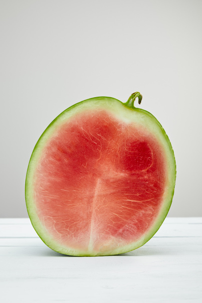 ripe red delicious watermelon half on wooden white table isolated on grey - Foto, Bild