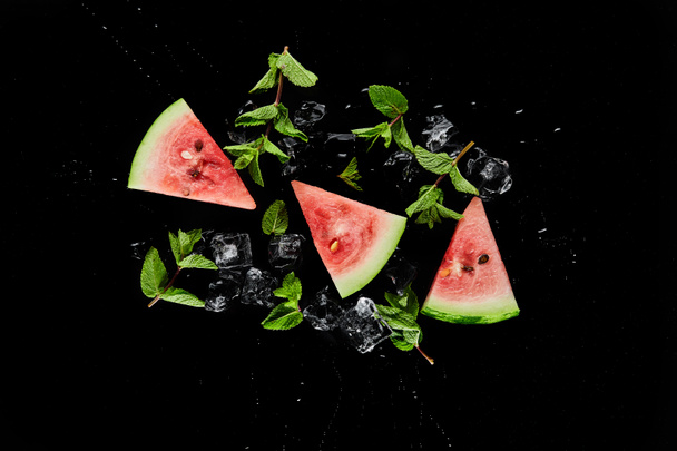 top view of red watermelon slices with mint and ice isolated on black - Fotó, kép