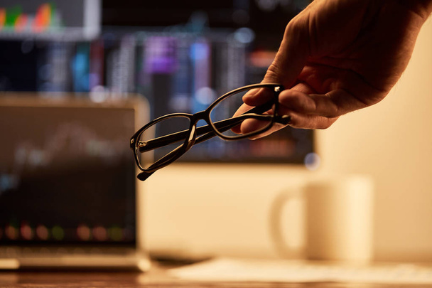обрізаний вид дорослого чоловіка тримає окуляри в офісі
  - Фото, зображення