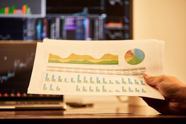 cropped view of adult man holding papers with charts and graphs  - Foto, imagen