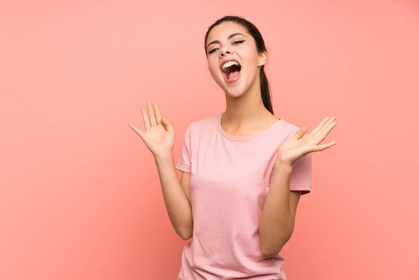 Teenager Mädchen über isoliertem rosa Hintergrund mit überraschendem Gesichtsausdruck - Foto, Bild