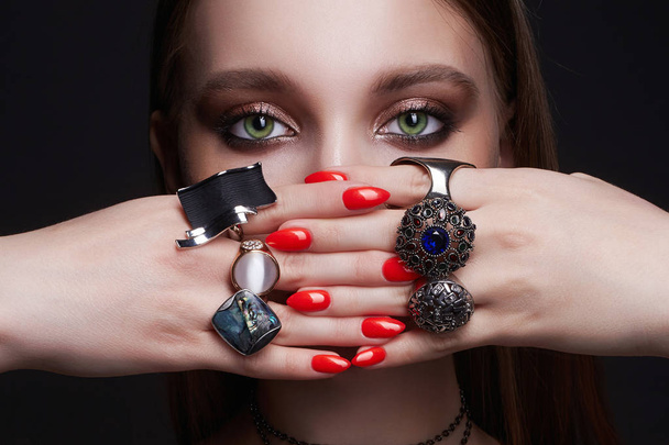 schoonheid vrouw portret. vrouwelijke handen met sieraden ringen - Foto, afbeelding