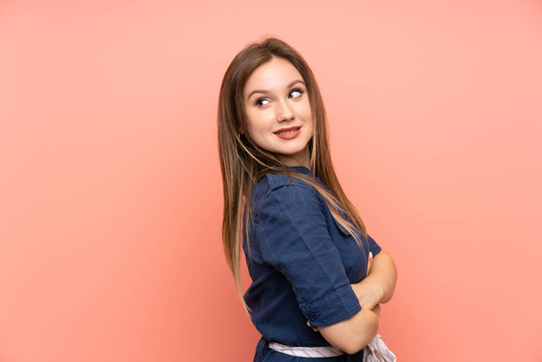 Teenager girl over isolated pink background with arms crossed and happy - Foto, afbeelding