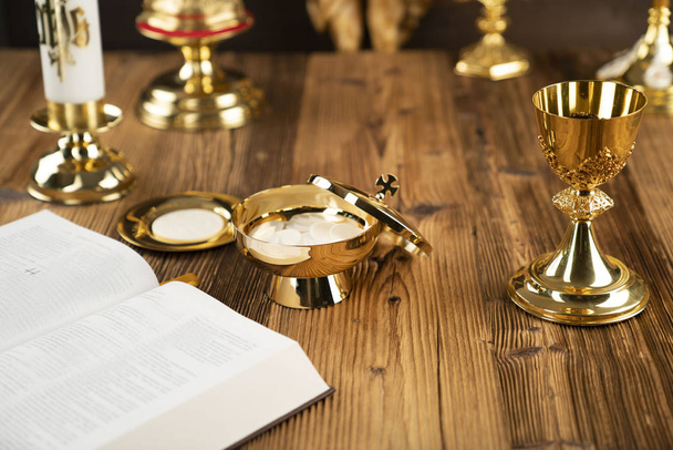 Ο Σταυρός, το χρυσό δισκοπότηρο και η Βίβλος στο ξύλινο βωμό. - Φωτογραφία, εικόνα