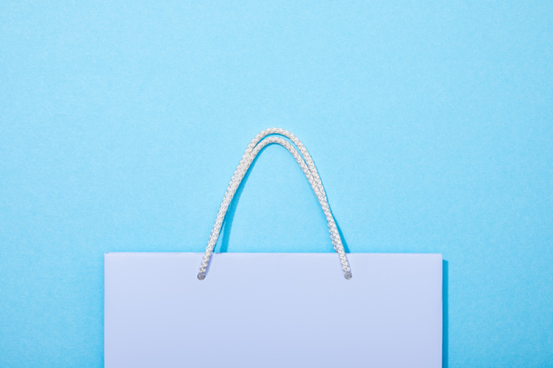 top view of purple shopping bag on blue  - Fotografie, Obrázek