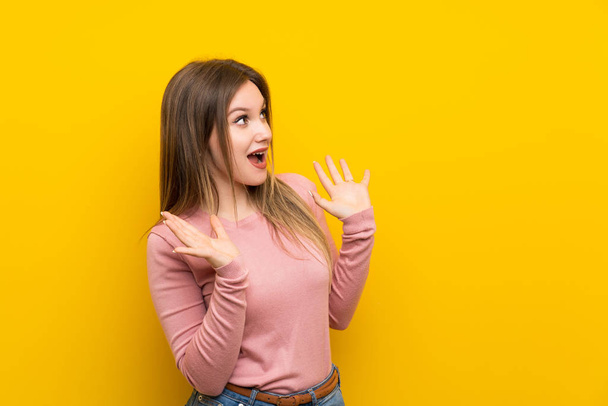 Teenager Mädchen über isolierten gelben Hintergrund mit Überraschung Gesichtsausdruck - Foto, Bild