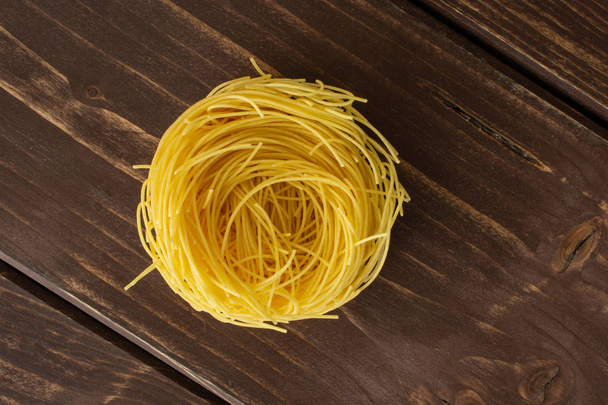 Angel hair pasta on brown wood - Foto, Imagem