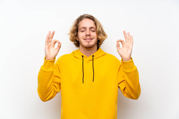 Zen beyaz duvar üzerinde Sweatshirt ile sarışın adam poz - Fotoğraf, Görsel