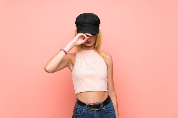 Young blonde woman with hat with tired and sick expression - Фото, изображение