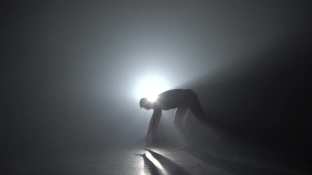Homem praticando capoeira na escuridão contra holofotes no estúdio escuro
. - Filmagem, Vídeo