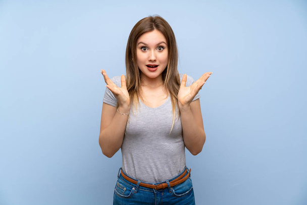 Teenager girl over isolated blue wall with shocked facial expression - Photo, image