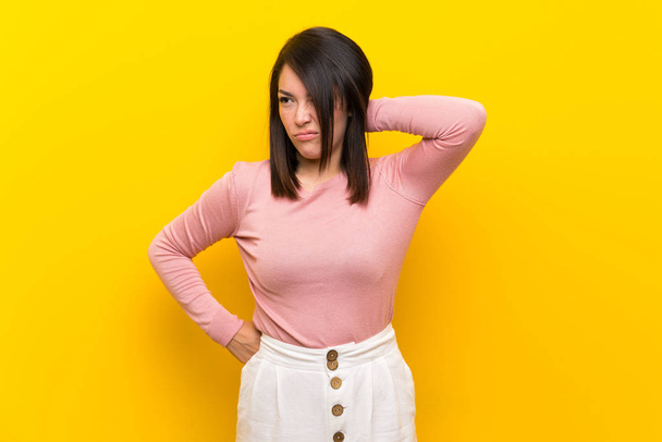 Giovane donna messicana su sfondo giallo isolato con mal di collo
 - Foto, immagini