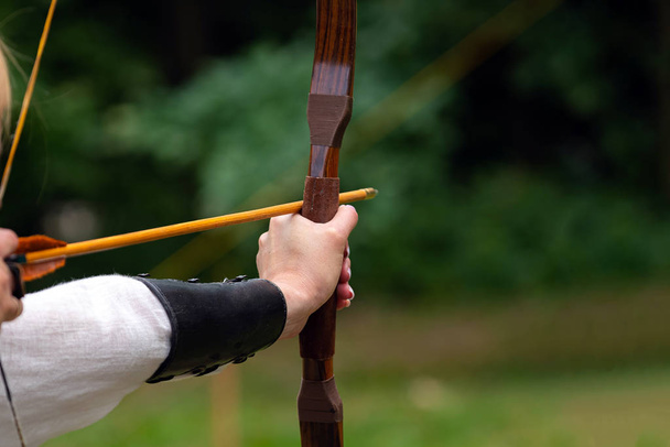 Archer holds his bow aiming at the target. Archery competition, outdoor activity - Photo, Image