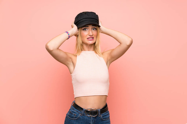 junge blonde Frau mit Hut frustriert und nimmt Hände auf den Kopf - Foto, Bild