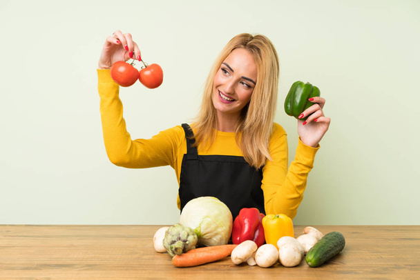 Jovem feliz mulher loira com lotes de legumes
 - Foto, Imagem