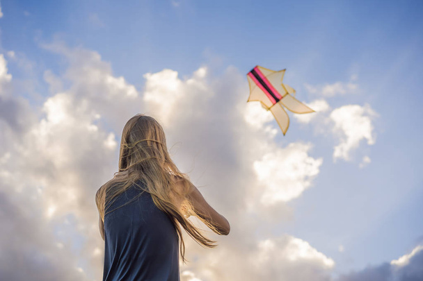 A young woman launches a kite on the beach. Dream, aspirations, future plans - Fotó, kép