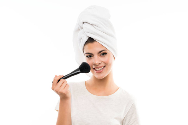 Teenager Mädchen über isolierten weißen Hintergrund mit Make-up-Pinsel - Foto, Bild