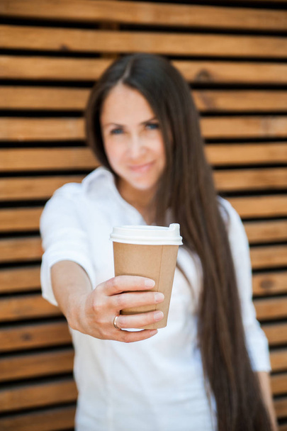 Mulher bonita com xícara de papel de café na casa de café
. - Foto, Imagem