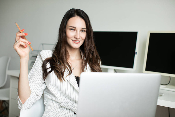 tyttö toimistossa kädessään kannettava tietokone
 - Valokuva, kuva
