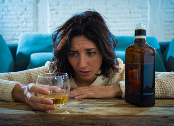Drunk alcoholic depressed woman drinking scotch whiskey spirits alone at home. Feeling hopeless, week and lonely. In People lifestyle, Depression, alcohol addiction, alcoholism and drug abuse concept. - Фото, изображение