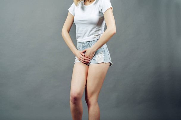 Nainen hoikka jalat pukeutunut lyhyt denim shortsit puristimet hän
 - Valokuva, kuva