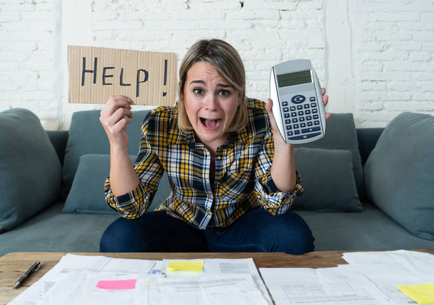 Worried young woman feeling stressed while accounting business and home finances. Desperate showing Help sign and calculator. In bad economic situation, paying debts, bills and financial problems. - Fotoğraf, Görsel