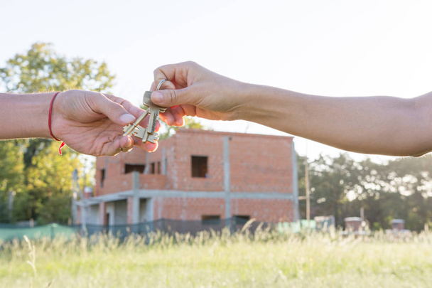Agente de bienes raíces dando una llave de una casa nueva al propietario
 - Foto, imagen