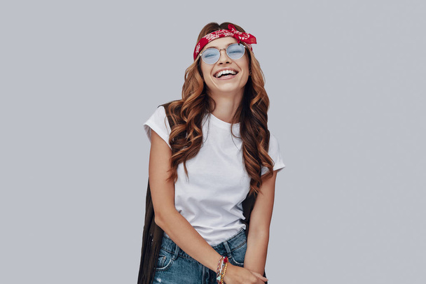 Attractive stylish young woman laughing while standing against grey background - Φωτογραφία, εικόνα