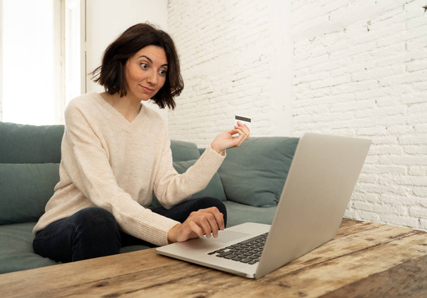 Attractive woman doing online shopping with credit card and laptop. Happy buying on the internet fashion and clothes on sales, travel offers and food delivery. In e-commerce and technology concept - Photo, Image