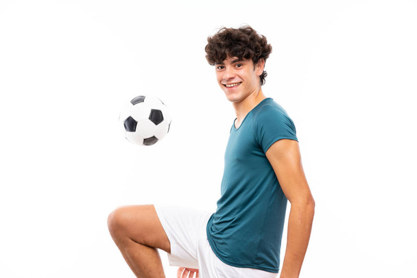 Junger Fußballspieler über isolierte weiße Wand - Foto, Bild