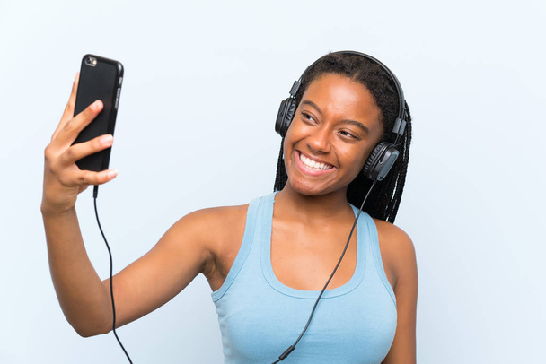 Ragazza afro-americana adolescente con lunghi capelli intrecciati ascoltare musica con un cellulare
 - Foto, immagini