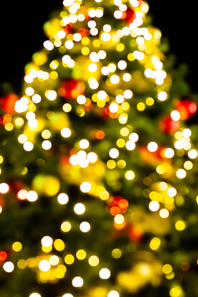 γιορτινό χριστουγεννιάτικο δέντρο διακοσμημένο με πολύχρωμα θόλωμα χρυσά φώτα, βάση πολύχρωμο φόντο - Φωτογραφία, εικόνα
