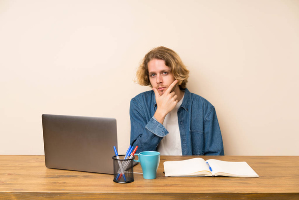 Blonde man with a laptop thinking an idea - Фото, зображення