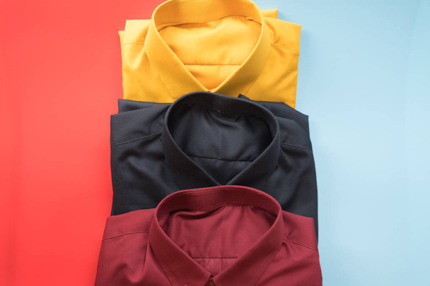 Куча цветных мужских рубашек на красном и синем фоне
 - Фото, изображение