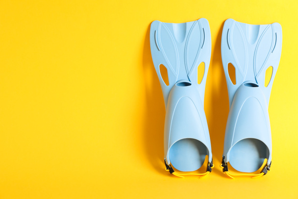 Pair of blue flippers on yellow background, space for text - Photo, Image