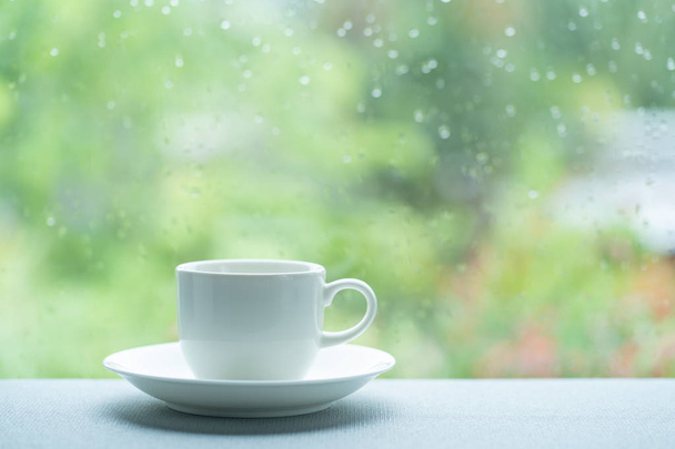 雨の日のホワイトコーヒーカップ - 写真・画像