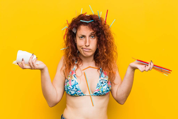 Young caucasian redhead woman angry with the abusive use of plastic - 写真・画像