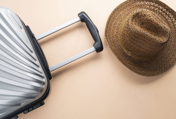Flat lay grey suitcase with brown hat on pastel background. trav - Fotó, kép