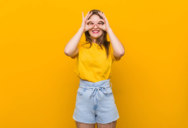 Mladá žena v pubertě na žluté košili, která ukazovala dobře nápis přes oči - Fotografie, Obrázek