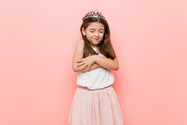 Kislány visel egy hercegnő meg Hugs, mosolygós gondtalan és boldog. - Fotó, kép