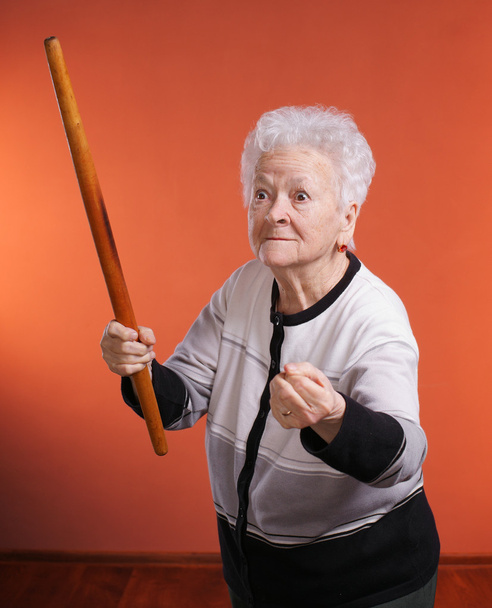 Старая сердитая женщина угрожает скалкой
 - Фото, изображение