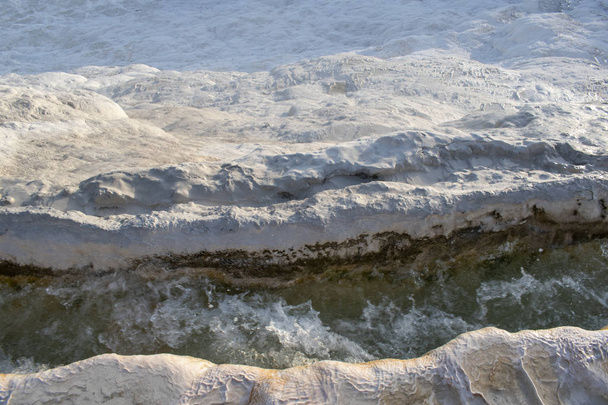トルコ、デニズリの水によって堆積した堆積岩の有名な自然のサイト、パムッカレ(コットン城)のトラバーチンテラスの温泉からの流れる水の詳細 - 写真・画像
