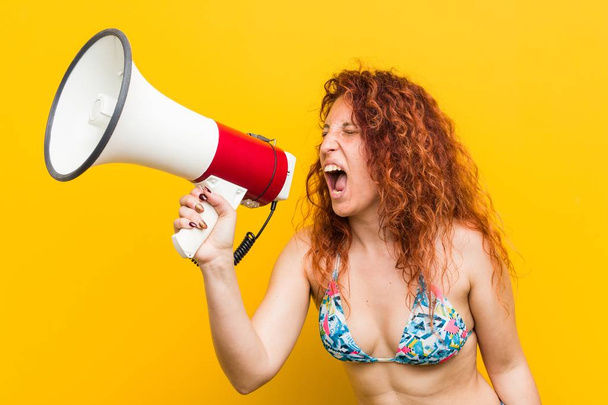 Young caucasian redhead woman holding a megaphone - Foto, Imagem