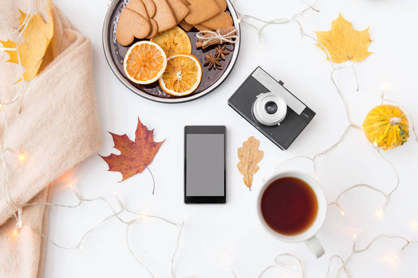 smartphone, tea, camera, cookies and autumn leaves - Photo, image