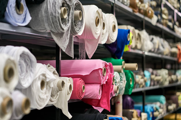 Fabric warehouse with many multicolored textile rolls - Foto, afbeelding