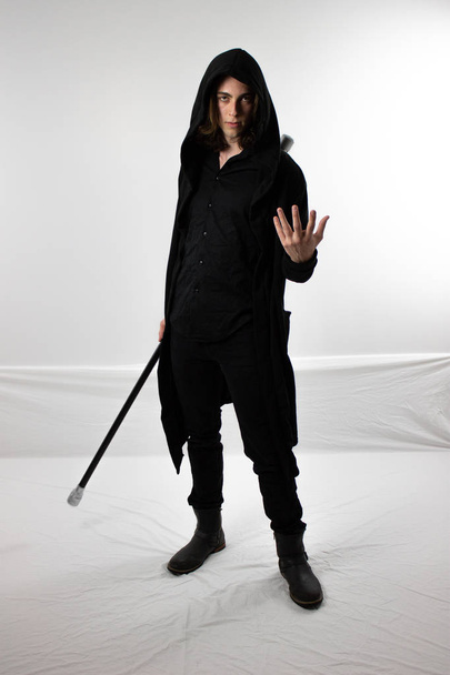 dunkler Krieger Jäger in schwarzer Kapuze mit Stab - Foto, Bild
