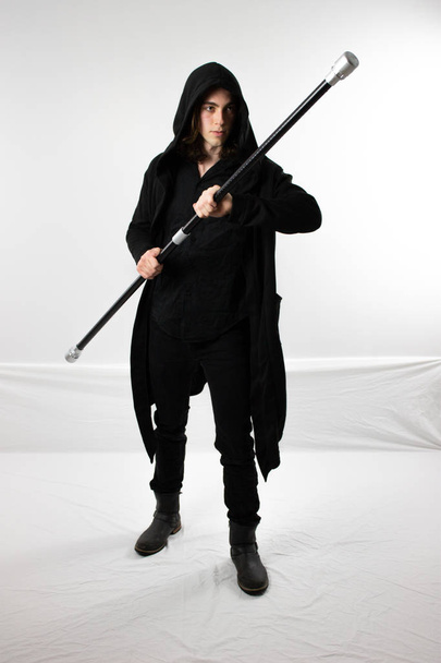 dunkler Krieger Jäger in schwarzer Kapuze mit Stab - Foto, Bild